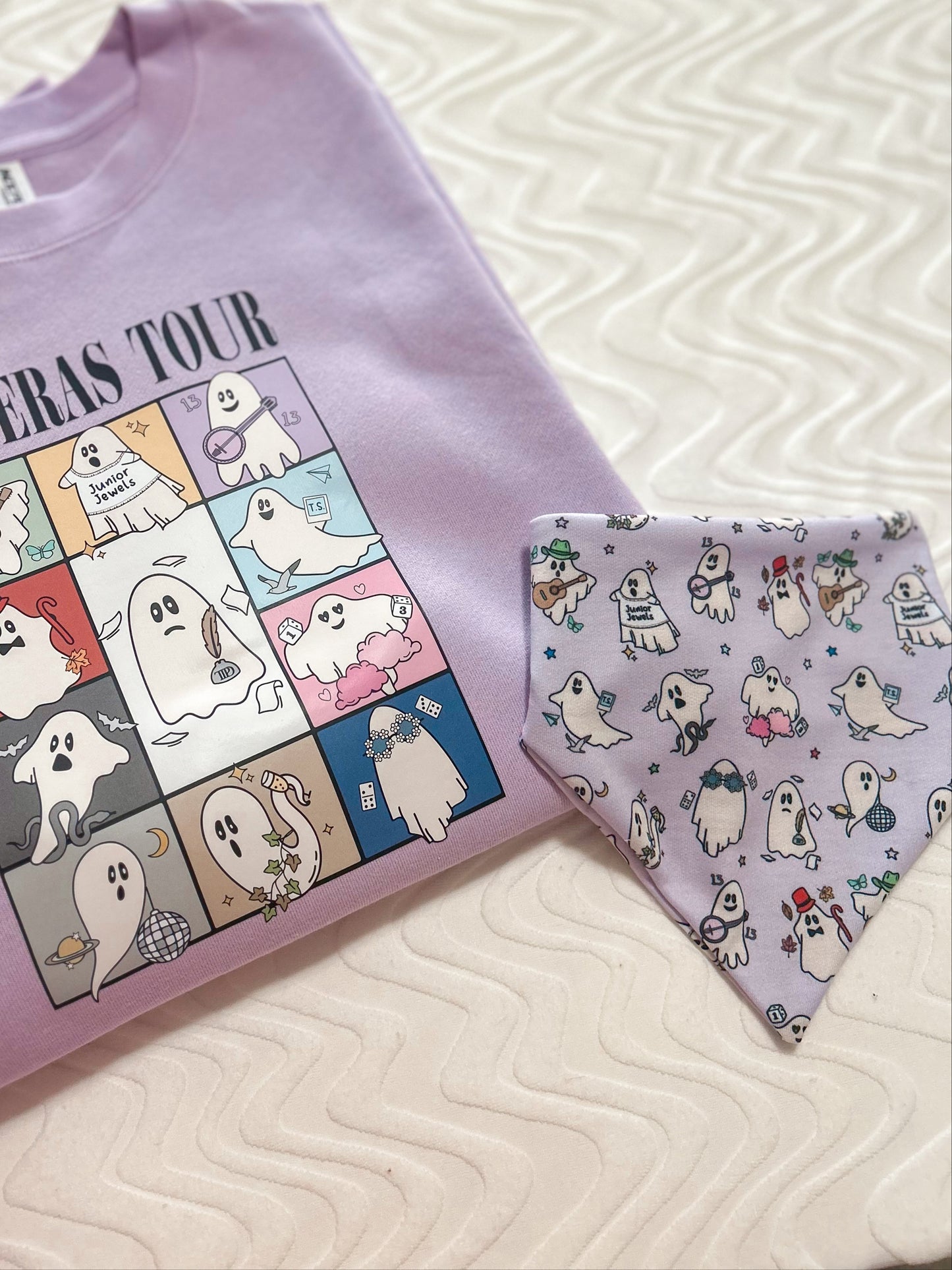 Purple t-shirt with cartoon ghost design and matching bandana on a textured surface.