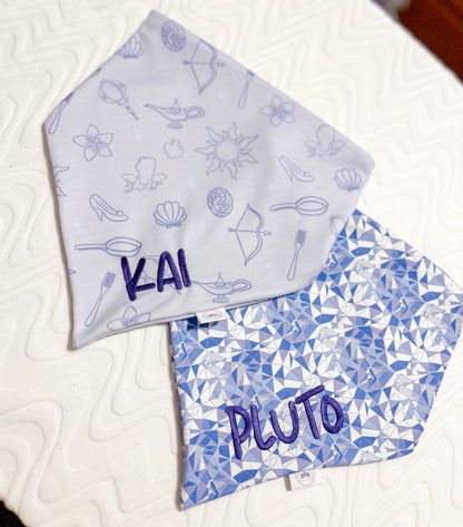 Two fabric bandanas with 'Kai' and 'Pluto' printed on them, one with a purple geometric pattern and the other with princess icons. 